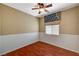 Bedroom featuring wood floors, modern ceiling fan, and large window at 3609 Blue Pimpernel Ave, North Las Vegas, NV 89081