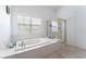 Large primary bathroom featuring soaking tub, glass shower, bright window and neutral finishes at 4116 Villa Flora St, Las Vegas, NV 89130