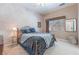 Inviting bedroom with soft carpet, a ceiling fan, and a large window providing natural light at 4116 Villa Flora St, Las Vegas, NV 89130