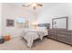 Comfortable bedroom with neutral tones, ceiling fan, and dresser with mirror at 4116 Villa Flora St, Las Vegas, NV 89130