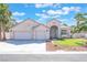 Charming home featuring a three-car garage, arched entryway, manicured lawn, and mature palm trees at 4116 Villa Flora St, Las Vegas, NV 89130