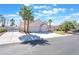 Charming home featuring a three-car garage, arched entryway, manicured lawn, and mature palm trees at 4116 Villa Flora St, Las Vegas, NV 89130