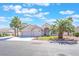 Charming home featuring a three-car garage, arched entryway, manicured lawn, and mature palm trees at 4116 Villa Flora St, Las Vegas, NV 89130
