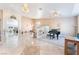 Open-concept living room with tile floors, grand piano, and elegant chandeliers providing ample lighting at 4116 Villa Flora St, Las Vegas, NV 89130