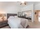 Bright main bedroom featuring neutral walls, carpet floors, a ceiling fan, and mirrored closet doors at 4116 Villa Flora St, Las Vegas, NV 89130