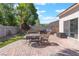 Paver patio with outdoor furniture, privacy wall, artificial turf, and sliding glass door into the home at 4116 Villa Flora St, Las Vegas, NV 89130