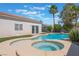 Inviting backyard pool and hot tub with artificial turf alongside a sliding glass door to the home at 4116 Villa Flora St, Las Vegas, NV 89130