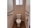 Compact toilet room featuring safety grab bars and tile flooring, designed for functionality and ease of access at 5005 Wild Thyme Ave, Las Vegas, NV 89131