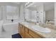 Bright bathroom featuring dual sinks, a large mirror, and a modern soaking tub at 5512 Goldbrush St, Las Vegas, NV 89130