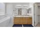 Bright bathroom featuring dual sinks, a large mirror, and a modern soaking tub at 5512 Goldbrush St, Las Vegas, NV 89130