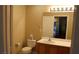 Bathroom featuring a single sink vanity, toilet, and a mirror reflecting the doorway and bedroom beyond at 63 E Agate Ave # 202, Las Vegas, NV 89123