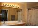 Bathroom featuring double sinks, wood cabinets, and a large mirror with Hollywood-style lighting at 63 E Agate Ave # 202, Las Vegas, NV 89123