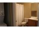Bathroom includes a toilet, vanity, shower with white curtain, and a stacked washer and dryer at 63 E Agate Ave # 202, Las Vegas, NV 89123