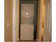 A compact stacked washer and dryer unit is nestled in a small utility closet or nook at 63 E Agate Ave # 202, Las Vegas, NV 89123