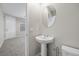 Modern powder room with a pedestal sink, oval mirror, and neutral wall paint at 6460 Raven Hall St, North Las Vegas, NV 89084