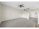 Inviting living area with gray carpet and fan. Features a view of the home's staircase at 6460 Raven Hall St, North Las Vegas, NV 89084