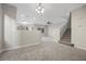 Open living space with gray carpet, staircase and views of kitchen and dining areas provides a modern feel at 6460 Raven Hall St, North Las Vegas, NV 89084