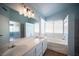 Bright bathroom featuring a soaking tub, double vanity with white cabinets, and a separate shower at 6524 Rain Forest Dr, Las Vegas, NV 89108