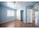 This bedroom features wood-look flooring, closet with sliding doors, and window for ample natural light at 6524 Rain Forest Dr, Las Vegas, NV 89108