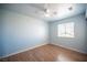 This bedroom features wood-look floors, a ceiling fan, and a window for ample natural light at 6524 Rain Forest Dr, Las Vegas, NV 89108