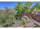 Serene backyard featuring a small turf area, rock landscaping, and mature trees at 68 Vista Del Mar St, Henderson, NV 89012