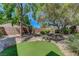 Landscaped backyard with easy keep rocks and green grass area and mature trees at 68 Vista Del Mar St, Henderson, NV 89012