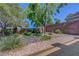 Landscaped backyard with decorative rocks and lush green plants and synthetic turf at 68 Vista Del Mar St, Henderson, NV 89012