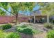 Backyard with lush landscaping, a turf lawn, decorative rocks, and a covered patio at 68 Vista Del Mar St, Henderson, NV 89012