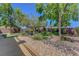 Picturesque backyard with decorative rock, lush trees, and manicured synthetic turf at 68 Vista Del Mar St, Henderson, NV 89012