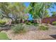 Backyard with decorative rocks, lush green plants, and synthetic turf at 68 Vista Del Mar St, Henderson, NV 89012