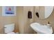 Powder room with a pedestal sink, toilet, and sailboat wall art at 68 Vista Del Mar St, Henderson, NV 89012