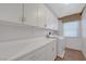 Bright laundry room with white cabinets, countertops and washer/dryer at 68 Vista Del Mar St, Henderson, NV 89012