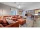 Spacious living room with a large leather sofa, wood-look flooring, and a partial view of the kitchen at 68 Vista Del Mar St, Henderson, NV 89012