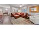 Open-concept living room featuring a leather sofa, area rug, wood-look floors, and natural light at 68 Vista Del Mar St, Henderson, NV 89012