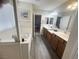 Bathroom featuring double sinks, bathtub, and wood-style floors leading to the bedroom at 6922 Majestic Palm Dr, Las Vegas, NV 89122