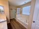 Bright bathroom with a shower over tub, white cabinets, and wood grain vinyl floor at 6922 Majestic Palm Dr, Las Vegas, NV 89122