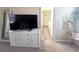 Bright bedroom featuring a white dresser, TV, and a glimpse into the bathroom at 6922 Majestic Palm Dr, Las Vegas, NV 89122