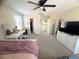 Large, carpeted bedroom with a ceiling fan, a dresser with a TV, and a view into the closet at 6922 Majestic Palm Dr, Las Vegas, NV 89122