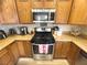 Close up shot of kitchen with stainless steel stove and microwave, and wooden cabinetry at 6922 Majestic Palm Dr, Las Vegas, NV 89122