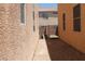 Narrow side yard featuring rock ground cover, stucco walls, and gated access at 6922 Majestic Palm Dr, Las Vegas, NV 89122