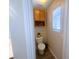 Small bathroom with a toilet, an upper cabinet, and natural light from the window at 6922 Majestic Palm Dr, Las Vegas, NV 89122