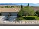 Home exterior featuring a three-car garage, desert landscaping, and a well-manicured lawn at 693 Hagens Aly, Mesquite, NV 89027