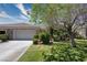 Well-manicured front lawn with mature trees and a spacious driveway leading to the garage at 693 Hagens Aly, Mesquite, NV 89027