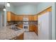 Well-lit kitchen with oak cabinets, granite countertops, and white appliances at 693 Hagens Aly, Mesquite, NV 89027