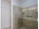 Walk-in shower features tile surround, glass door, grab bars, and overhead lighting at 693 Hagens Aly, Mesquite, NV 89027