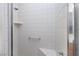 Tiled walk-in shower featuring a built-in seat and grab bar for safety and convenience at 693 Hagens Aly, Mesquite, NV 89027