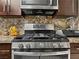 Kitchen showing stainless steel gas range stove with wooden cabinets and granite countertop at 7952 Lonette Ave, Las Vegas, NV 89147