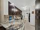 Well lit kitchen with stainless steel sink, granite countertop, and dark wood cabinets at 7952 Lonette Ave, Las Vegas, NV 89147