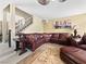 Open living area featuring a leather sectional sofa, staircase, and decorative carpet at 7952 Lonette Ave, Las Vegas, NV 89147