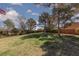Spacious backyard with healthy green grass, mature trees, and partial fencing at 8213 Cabin Springs Ave, Las Vegas, NV 89131